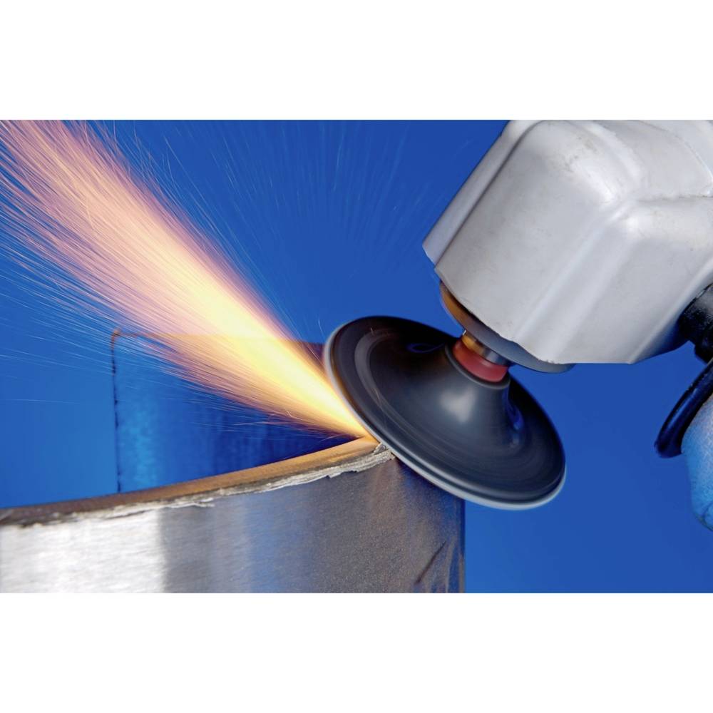 A machine grinds the edge of a metal piece, sparks flying. The main focus is on the activity of grinding.