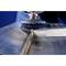 Metal grinding machine processes a welding seam on a metal surface. Close-up reveals precise grinding process.