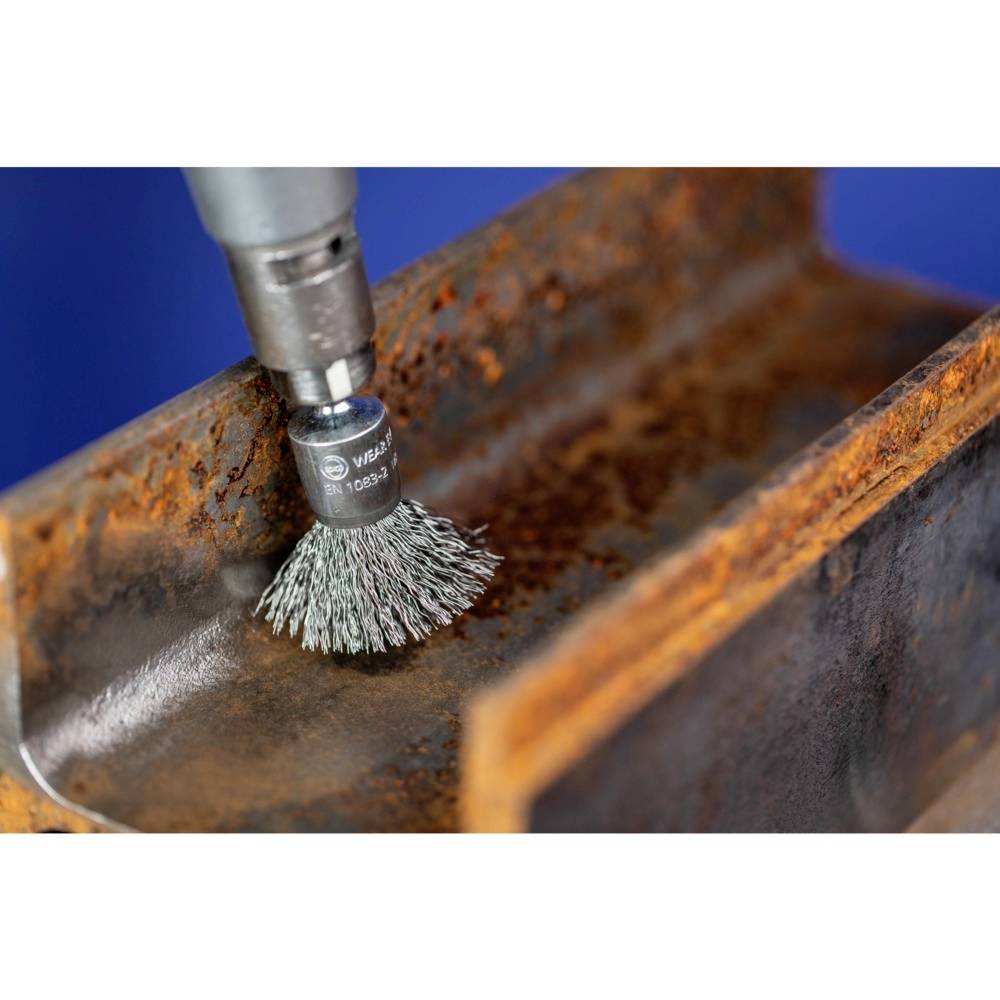 'Wire brush attachment on drill head cleans rusty metal surface.'