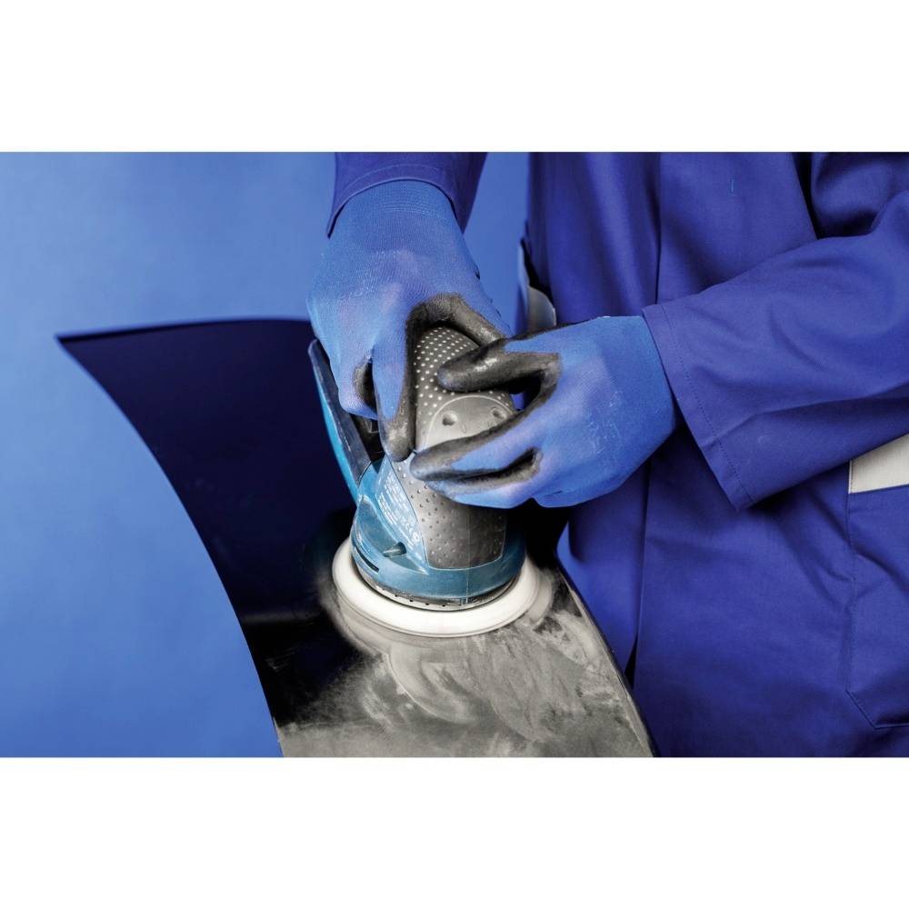 A person is grinding a metal surface with a grinding machine. They are wearing blue protective clothing and gloves.