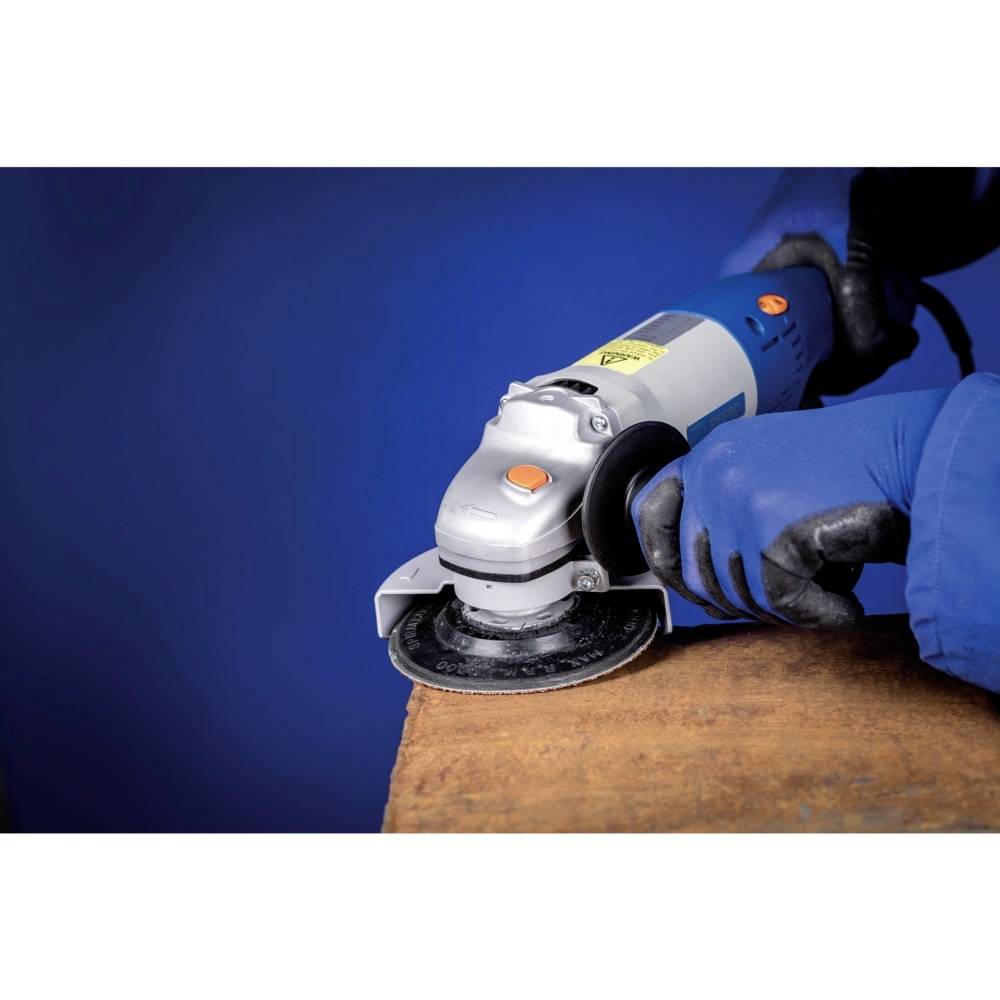 A person wearing blue gloves is using an angle grinder to work on a wooden surface. The background is blue.