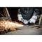 A person is cutting metal with an angle grinder, sparks flying. The person is wearing protective clothing and gloves.