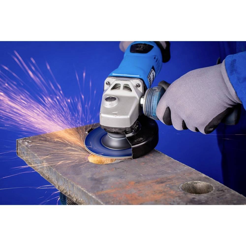 A person is grinding metal with an electric grinding machine, with sparks flying. The background is blue.