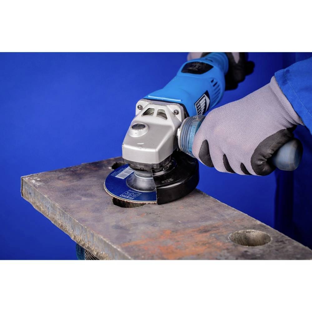 A person is grinding metal on a table using a blue angle grinder, protected by gloves.