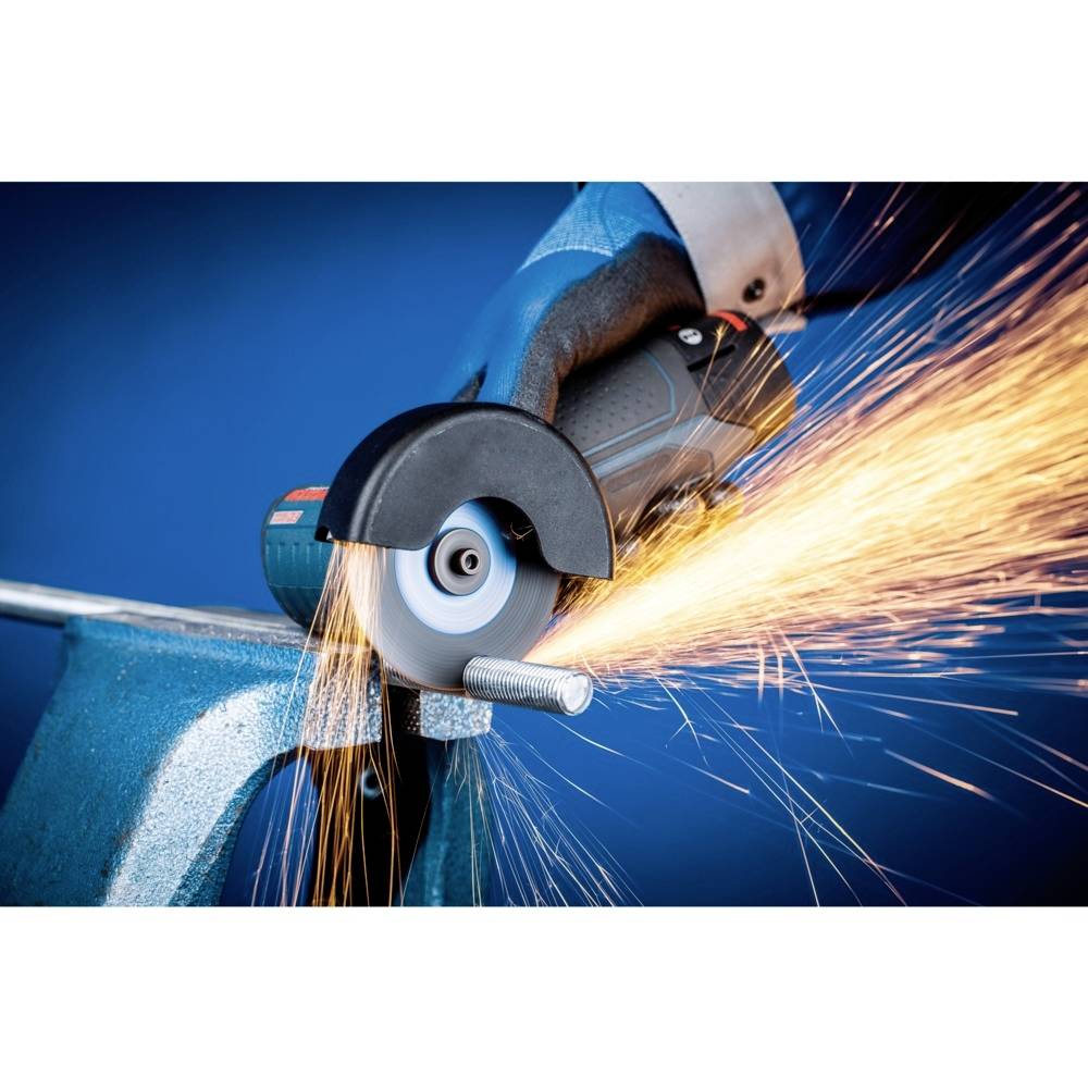 An angle grinder cuts through metal, sparks flying. It is being held by a person wearing protective equipment.