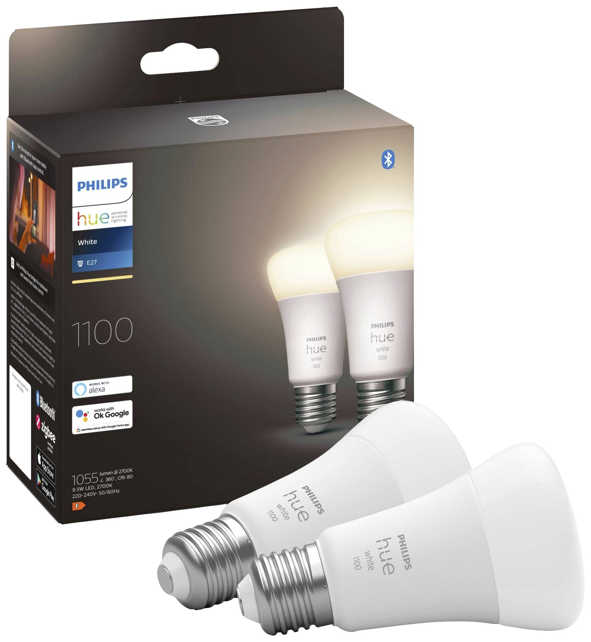 Two Philips Hue LED light bulbs in front of their product packaging. Packaging displays brand logo and compatibility with voice assistants.