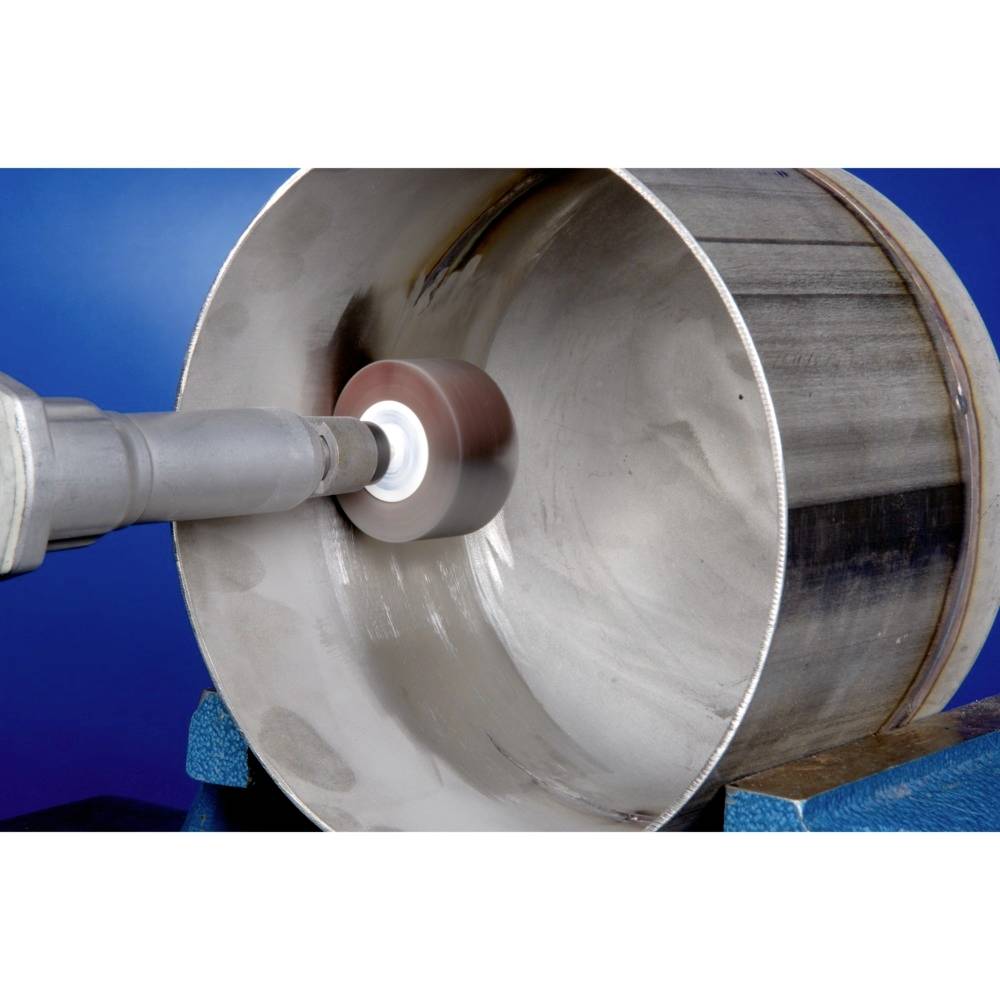 A polishing machine is processing the interior of a metal pipe. The machine ensures a smooth surface on the inside of the pipe.