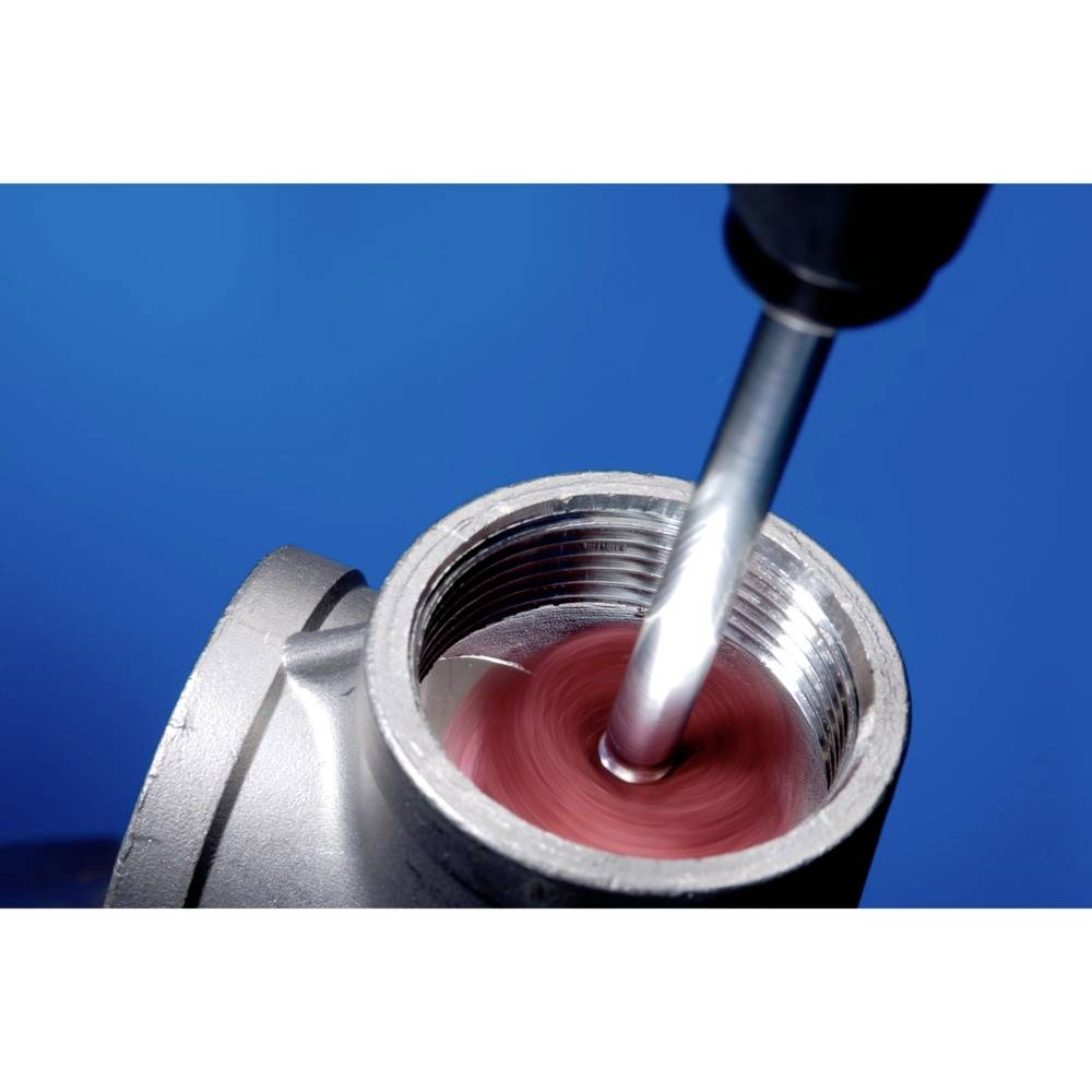 A drill is working on a metal pipe, positioned against a blue background. It moves rapidly and generates red sparks.