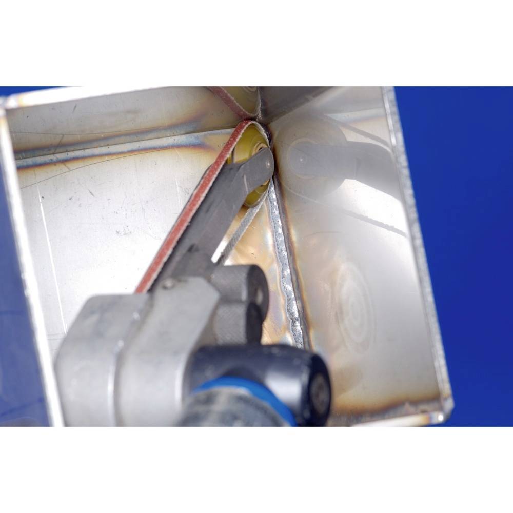 Close-up of a mechanical component within a metallic housing. A blue component is visible, surrounded by reflective surfaces.