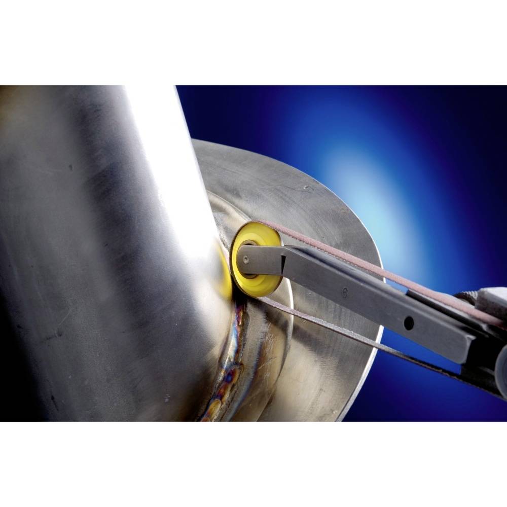 A metal grinding machine is working on a cylindrical metal piece. A blue light illuminates the scene, depicting industrial processing.