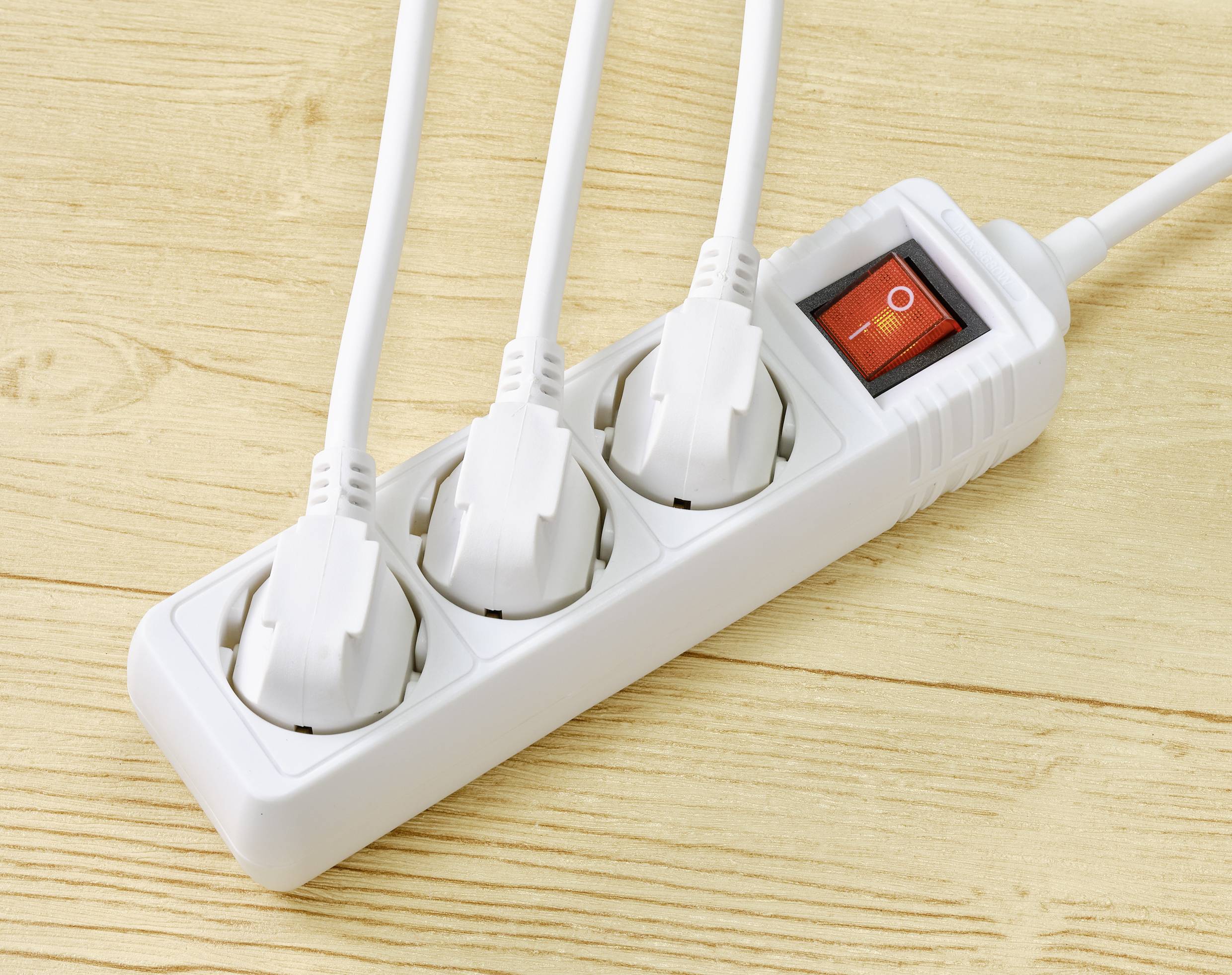 Triple socket on a wooden surface with three white cables plugged in and a red rocker switch in the 'Off' position.