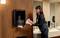 A woman takes paper towels from a dispenser in a modern bathroom.
