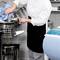 A chef is cleaning a large food processor in a professional kitchen, prepared for the next preparation.
