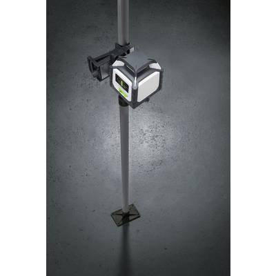 A laser levelling device is mounted on a tripod. It is illuminated and projects a green laser beam vertically onto the floor.
