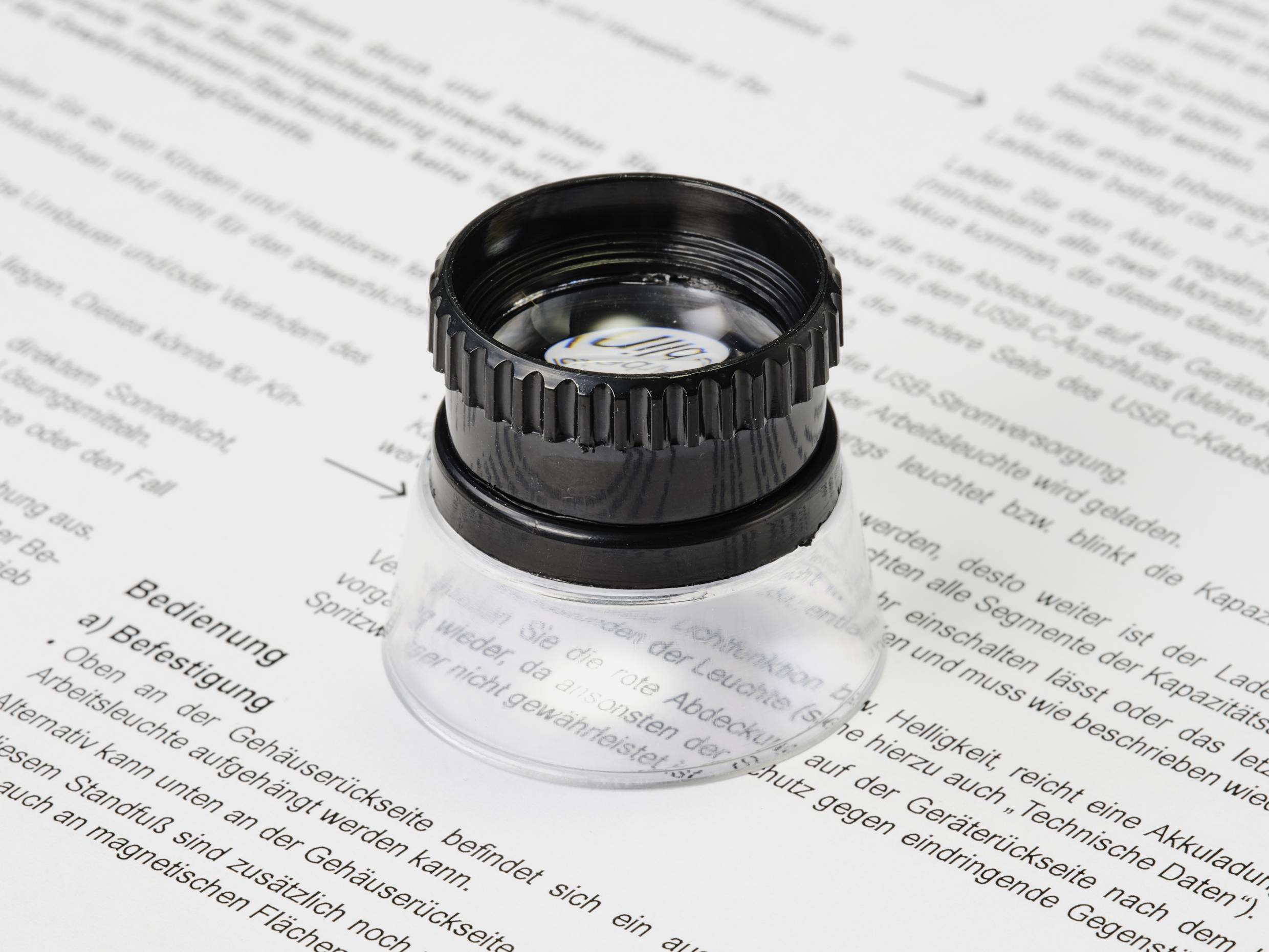A magnifying glass enlarges text on a printed page, making details and words more visible.