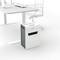 A white paper shredder beside a modern office desk with a chair. The paper shredder is ready for use in the office.