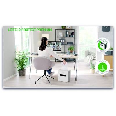 A person is sitting at a desk in their home office and using a shredder. A video conference is visible on the screen.