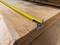 A yellow tape measure lies on a wooden board and indicates a length of approximately 36 centimetres.
