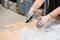 A person wearing gloves is opening a cardboard box with a knife in a warehouse, surrounded by bubble wrap.