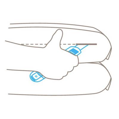 Thumb pointing upwards between two cushions. Objects or symbols are visible on the cushions.