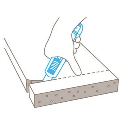 A hand uses a blue glue gun to apply adhesive along a dotted line on wood.