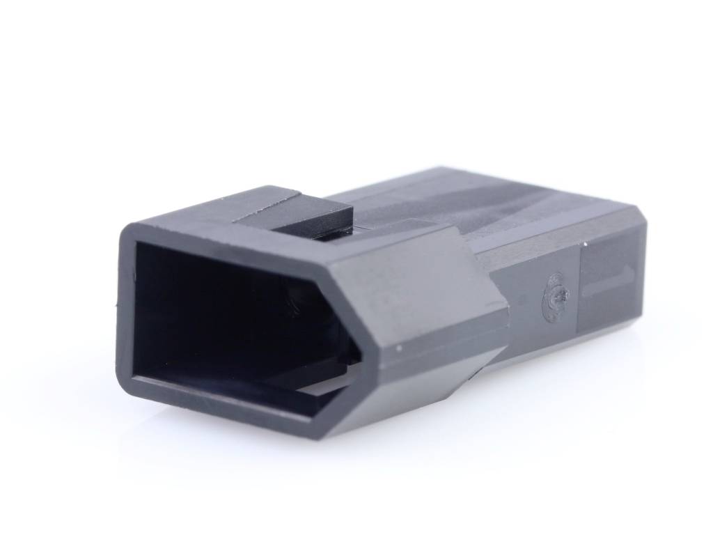 A black, rectangular plastic adapter with a bevelled end, lying on a white surface.