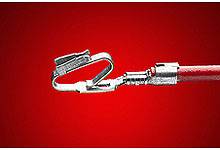 A metal clip with wire on a red background, close-up detail of a medical or technical device.