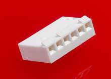 A white, five-notched plastic connector lies on a red background.