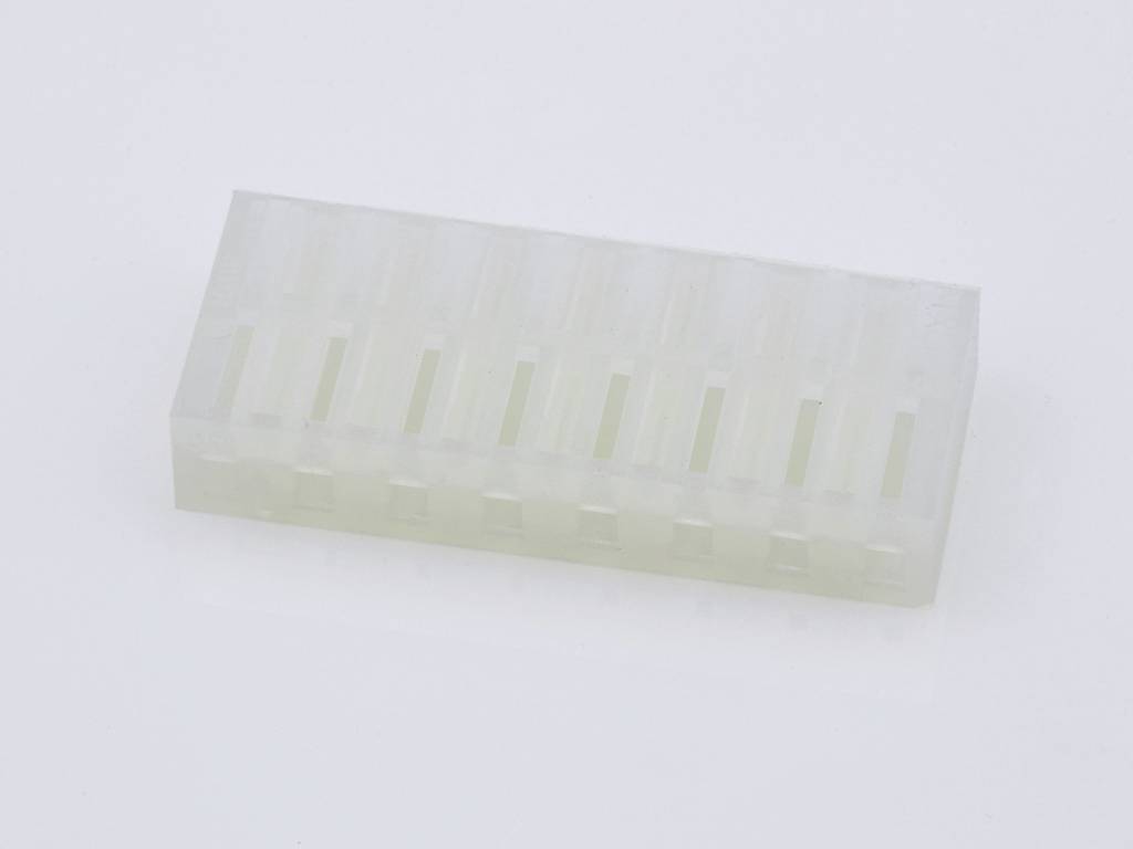 Rectangular transparent plastic block with multiple evenly distributed parallel slots, positioned on a white surface.