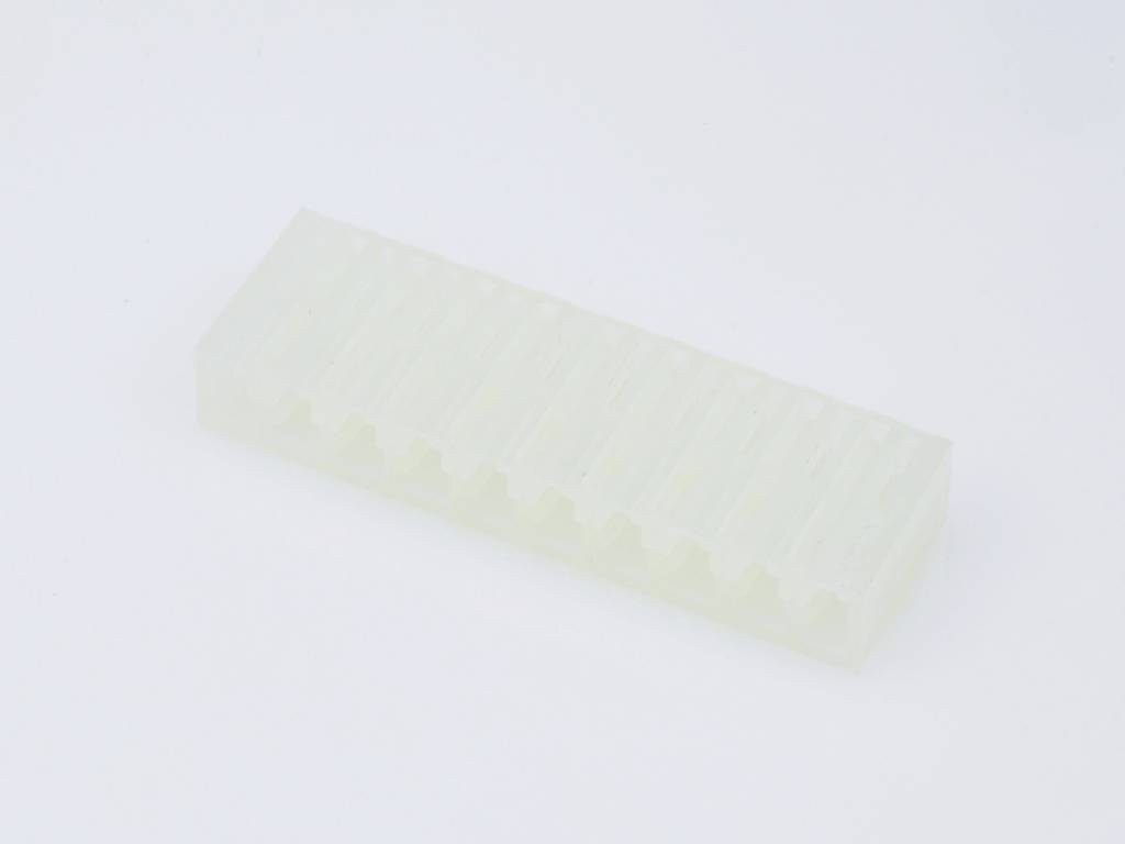 A transparent, rectangular plastic piece with a tooth-like profile rests on a white background.