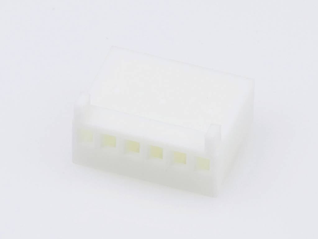 A white plastic plug with six connection sockets, viewed from above, on a white background.