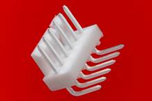 A white plug with eight metal pins on a red background, possibly used for electronic connections.