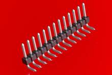 A component with 14 metal pins on a red background, likely an electrical plug or connector for technical equipment.
