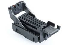 Black plastic mounting bracket with adjustable mechanism and perforated surface, set against a white background.