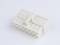 A white, rectangular multi-socket adaptor with several connection sockets on a flat surface.