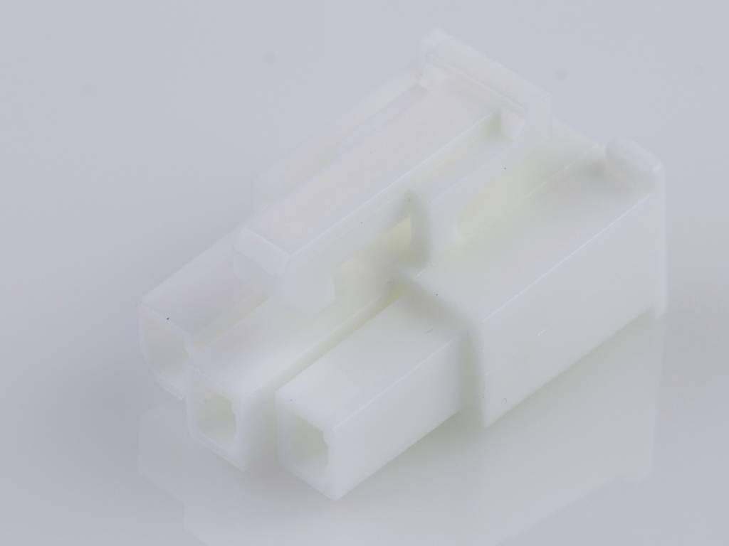 A white, rectangular plastic plug with multiple connection openings on a light surface, possibly for electronic devices.