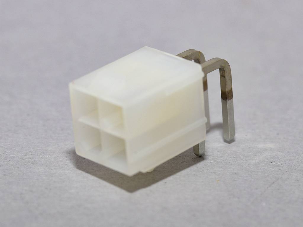 'Close-up of a white, square plastic plug with two metal pins against a grey background.'