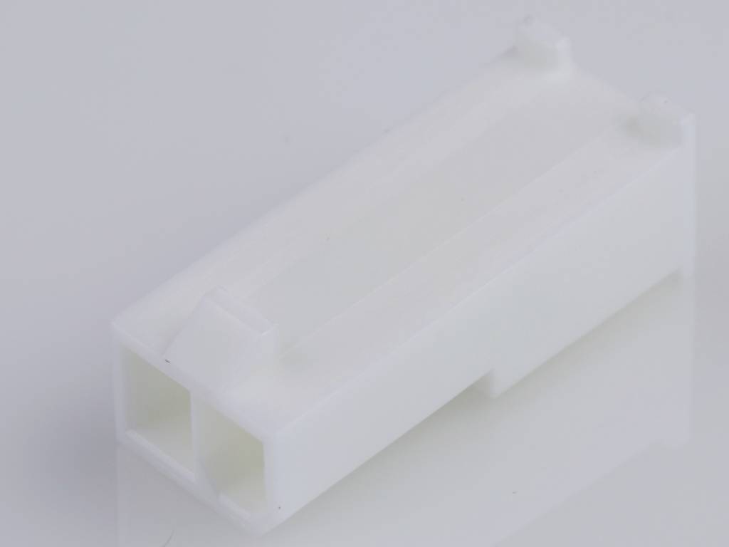 A white, rectangular plastic component, possibly an electrical plug, on a white background surface.