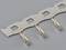 Connector pins on a metal strip used for electronic connections in circuit board assembly.