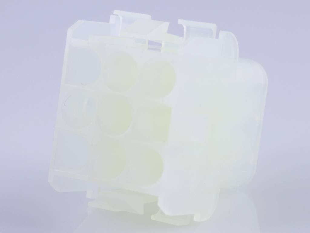 A white, rectangular plastic plug with multiple connection points, likely for electronic connections.