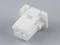 A white plastic component with two square openings and lateral protrusions against a grey background.