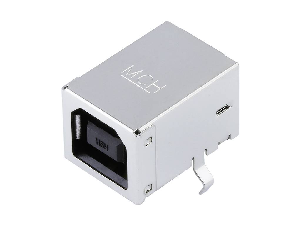 A square metal connector for electronic devices. It has a rectangular opening and is possibly a socket.