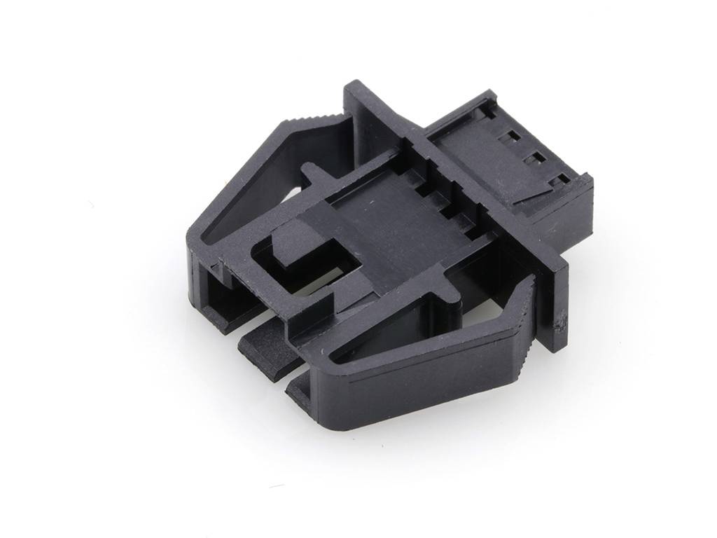 A black plastic clip with multiple inserts that can be used as a cable holder.