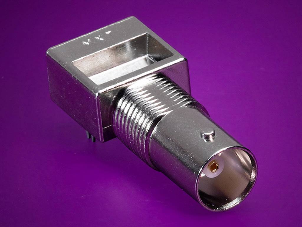 A metal coaxial plug on a purple background, with the socket for connecting a cable visible.