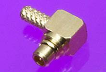 A gold-coloured metal connector with a ridged structure is resting on a purple surface.