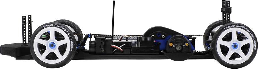 RC model chassis with two large white tyres, suspension and visible electronics on a black frame; side view.