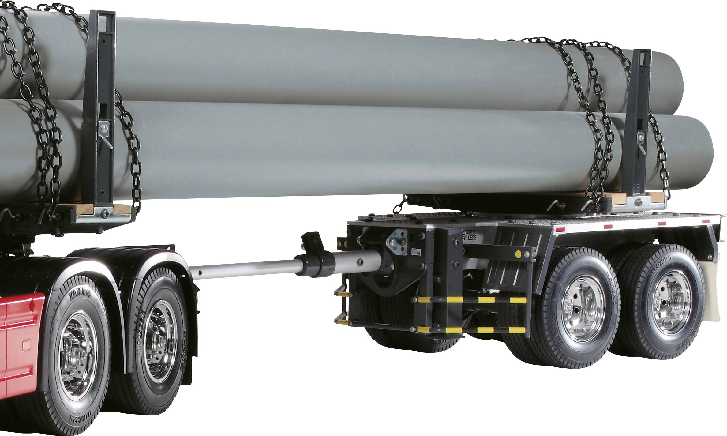 Lorry trailer secured with chains, carrying multiple large pipelines for transportation.