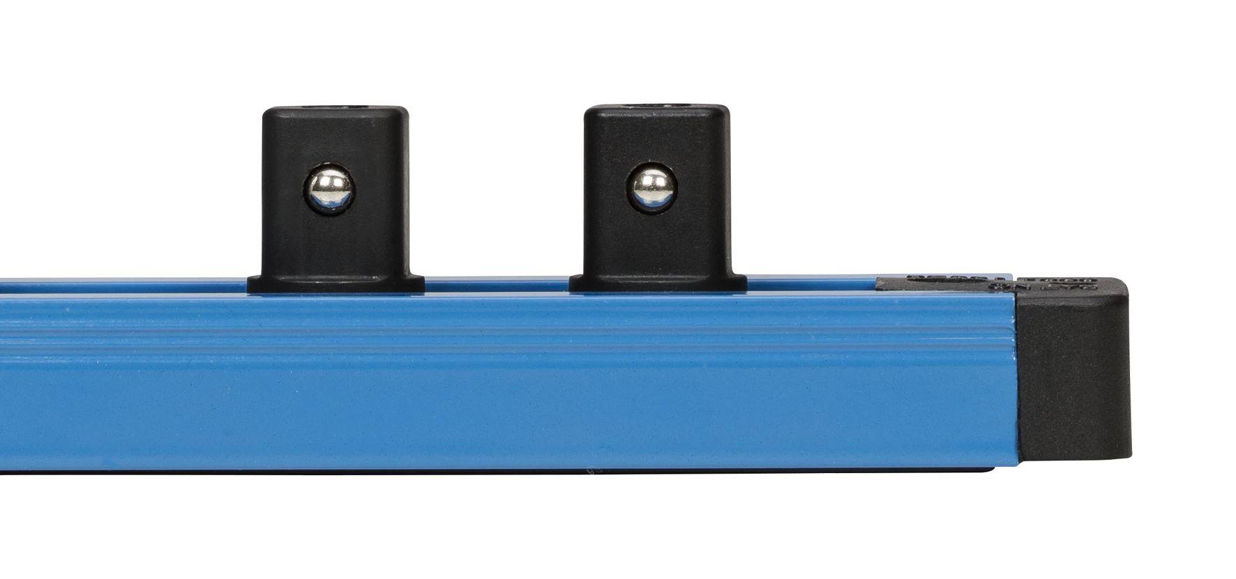 A blue, rectangular bar with two black brackets and silver balls mounted on it, photographed from a side perspective.