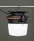An industrial pendant light with a hook, black casing and white, luminous dome, hanging from a metal rod.