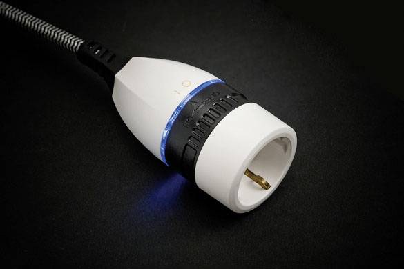 A white network plug with a blue illuminated ring lies on a black background. The plug has a black and grey cable connection.